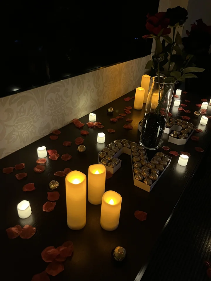 Hotel room reveal decorative details with candles, flowers and chocolates.