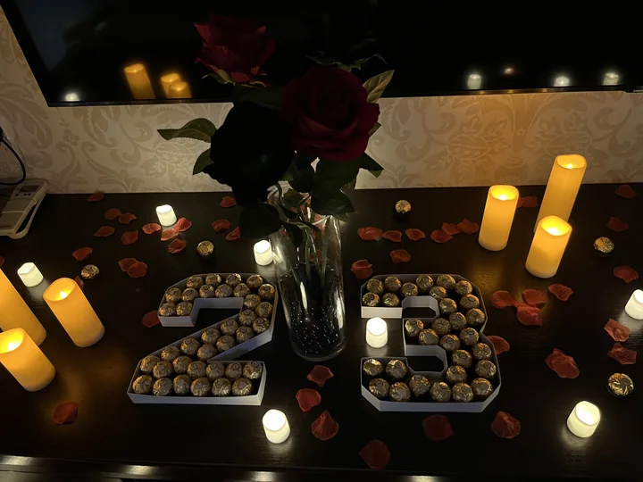 Hotel room reveal decorative details with LED candles, rose petals and flowers.