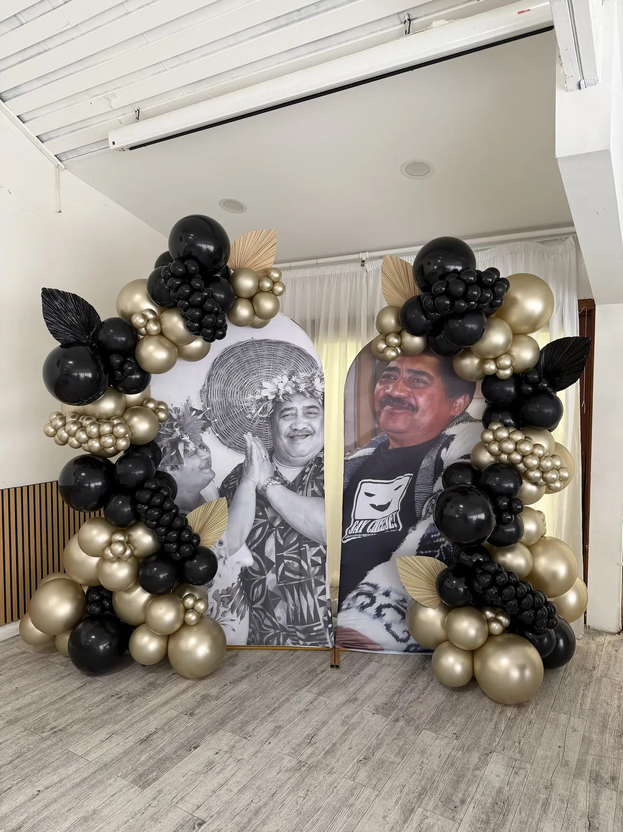 Black and gold balloon styling around personalised backdrop panels.