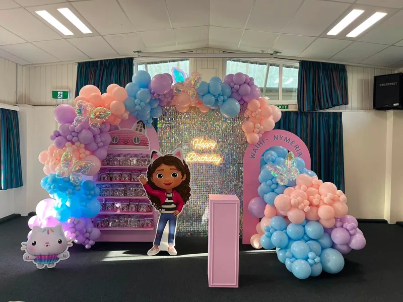 Pastel balloon installation with shimmer wall and layered themed backdrops.