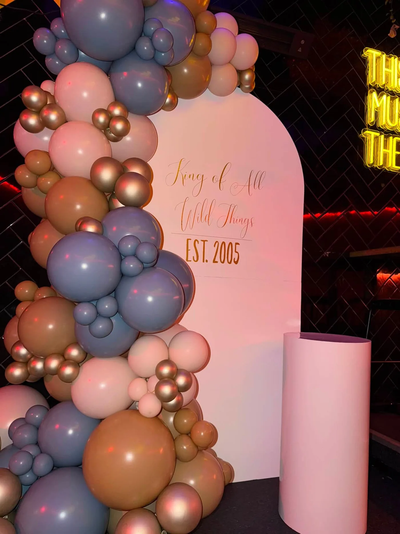 Elegant neutral balloon installation with personalised arch backdrop